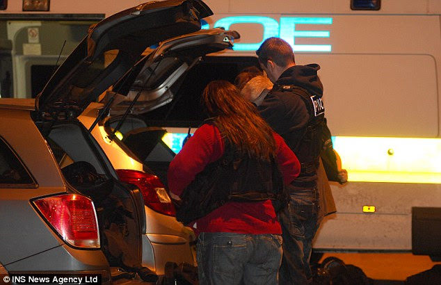 Mobilising: Officers loads up their cars as prepared to execute 14 warrants across the city 