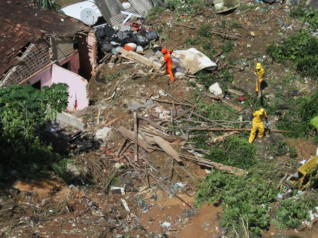 Funcionários trabalham em área onde pai e filho morreram após uma barreira deslizar e atingir a casa onde moravam no bairro da Bomba do Hemetério, na Zona Norte do Recife, durante a madrugada (Foto: Diego Nigro/JC Imagem)