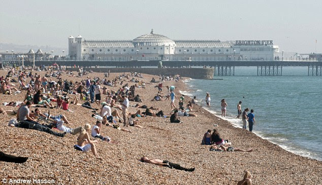 Tides out: High September temperatures brought people down to Brighton Beach for a spot of sunbathing