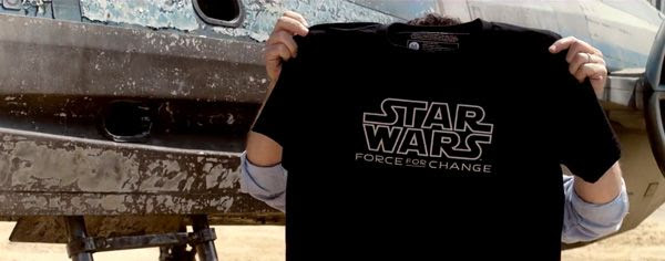 Director J.J. Abrams holds up a T-shirt that promotes the STAR WARS: FORCE FOR CHANGE campaign.
