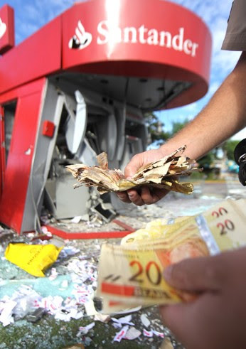 Dinheiro ficou espalhado pelo chão com a explosão (Foto: Alex de Jesus/O Tempo/Folhapress)