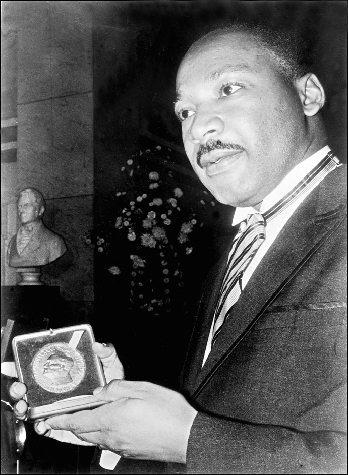 Clérigo EUA e líder do Movimento contra a segregação racial Martin Luther King, exibe 10 de dezembro de 1964 em Oslo seu Prêmio Nobel da Paz medalha.  (Foto: AFP)