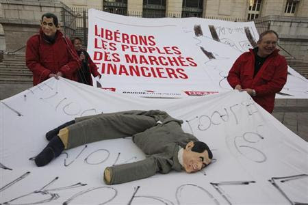 Members of the Front de Gauche political party hold a sheet with a puppet figure in the likeness of France's President Nicolas Sarkozy during a protest demonstration on the eve of traditional carnival festivities in Nice February 17, 2012. REUTERS/Eric Gaillard