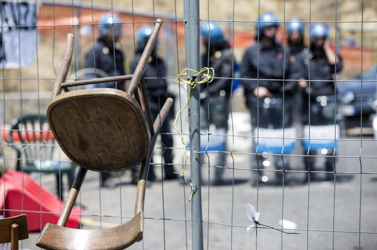 Italian policemen in riot gear stand as residents and far right demonstrators protest against a migrants&#39; arrival in the area in Rome, Friday, July 17, 2015. (Massimo Percossi/ANSA via AP)