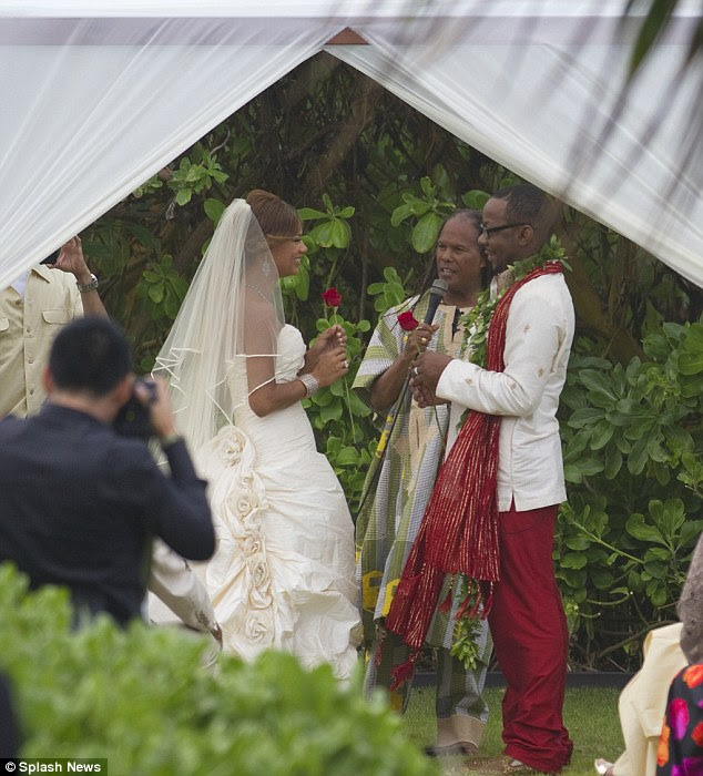 A kiss from a rose: Bobby and Alicia clutched a red rose under the tented area where they exchanged vows