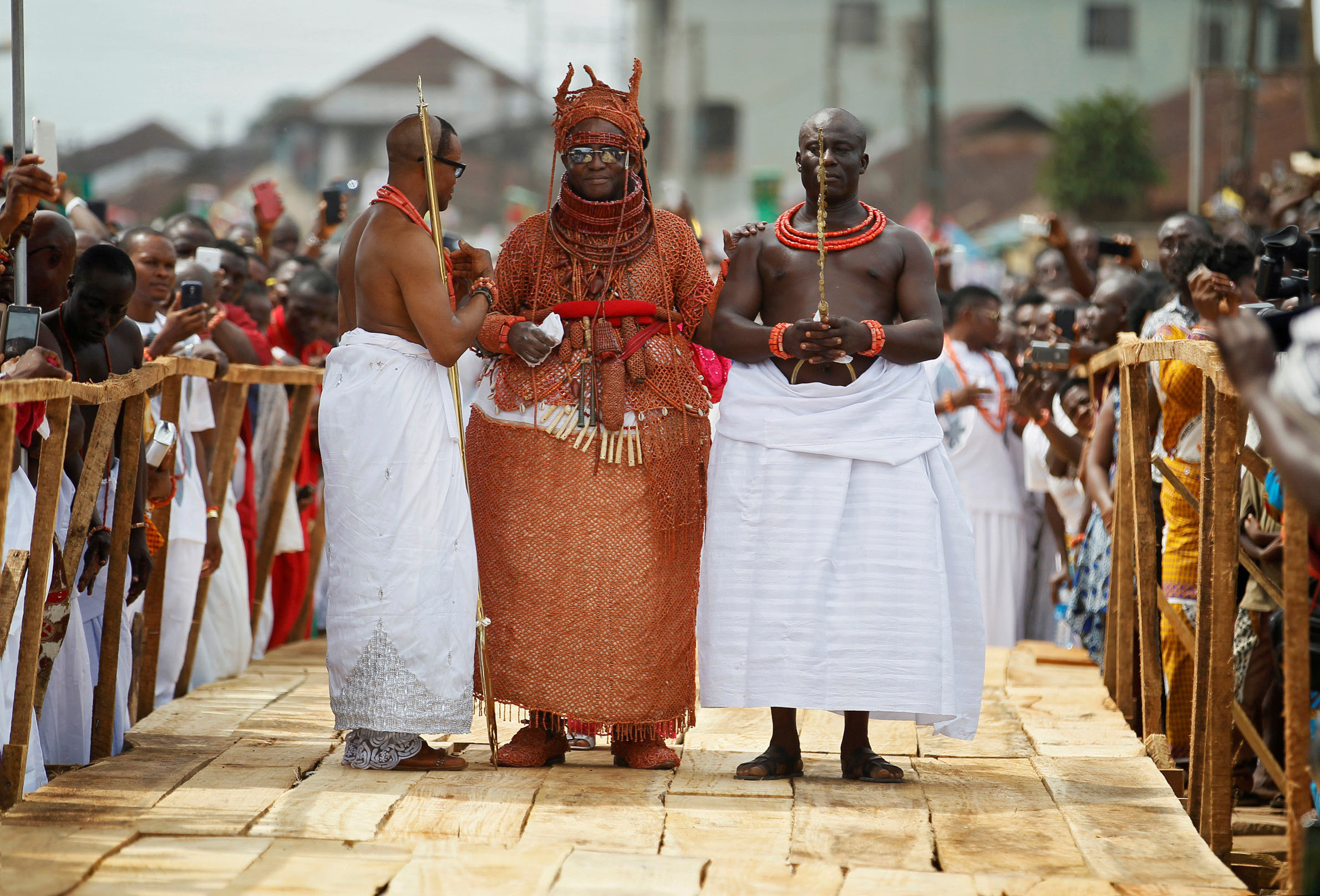 Newly crowned Oba of Benin Kingdom Eheneden Erediauwa is guided through a symbolic bridge by the palace chiefs during his coronation in Benin city, Nigeria October 20, 2016.REUTERS/Akintunde Akinleye
