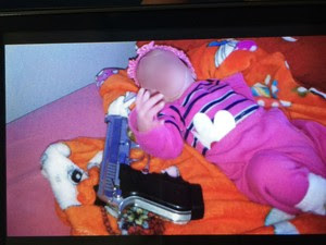 Bebê foi fotografada ao lado de arma em Balneário Piçarras (Foto: Polícia Militar/Divulgação)