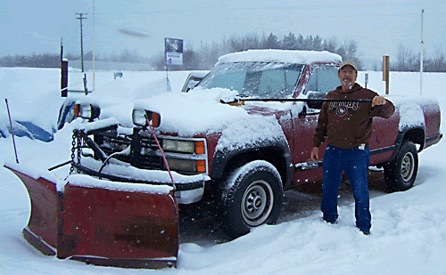 Hoolie helps clear snow from one of the plow trucks.