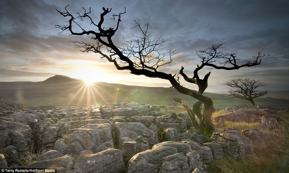 The sun sets over a landscape in Ingleborough in the Yorkshire Dales as the last of the longer autumn nights draw in 