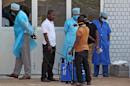 In this photo taken on Saturday, March 29, 2014, medical personnel at the emergency entrance of a hospital receive suspected Ebola virus patients in Conakry, Guinea. Senegal has closed its land border with neighboring Guinea to prevent the spread of the Ebola outbreak, which has killed at least 70 people. Senegal's Interior Ministry announced the border closure Saturday. It also said officials in the southern region of Kolda closed a weekly market which draws thousands of people from the neighboring West African countries of Guinea, Gambia and Guinea-Bissau. Guinea confirmed last week that several victims of hemorrhagic fever in the country's southern region had tested positive for Ebola. (AP Photo/ Youssouf Bah)