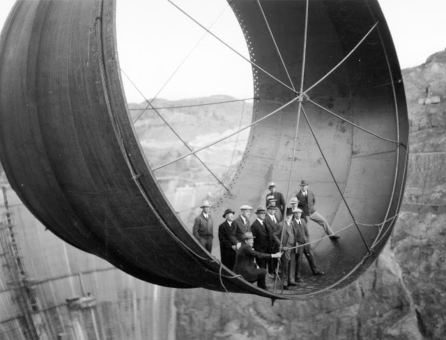 Men stand in a 45 ton steel pipe over the Hoover Dam, 1935