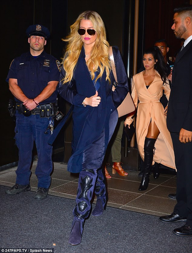 Looking glam: Khloe, 30, was dressed in a pair of purple cowboy boots with matching trousers and a long blue coat as she wore sunglasses at night