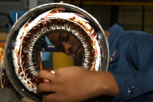 Photo of U.S. Navy electrictian working on a ventalation motor