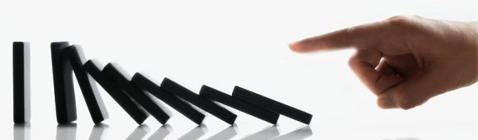 Businessman Touching Domino Pieces Arranged in a Line --- Image by © Royalty-Free/Corbis