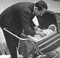 Man tending child during stroller walk.