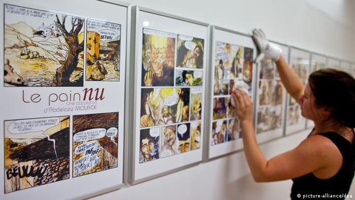 Eine Mitarbeiterin des Comic-Salons reinigt am Mittwoch (06.06.2012) während der Aufbauarbeiten in Erlangen (Mittelfranken) das Glas gerahmter Zeichnungen des marokkanischen Comic-Zeichners Abdelaziz Mouride. Im Rahmen des 15. Internationalen Comic-Salons beleuchtet eine Ausstellung die arabische Comic-Szene. Das wichtigste Festival für grafische Literatur im deutschsprachigen Raum hat noch bis 10. Juni geöffnet. Neben den Klassikern bestimmen längst auch gesellschaftspolitische Themen die grafische Literatur. Foto: Daniel Karmann dpa/lby (zu dpa 0042 vom 07.06.2012)  +++(c) dpa - Bildfunk+++
