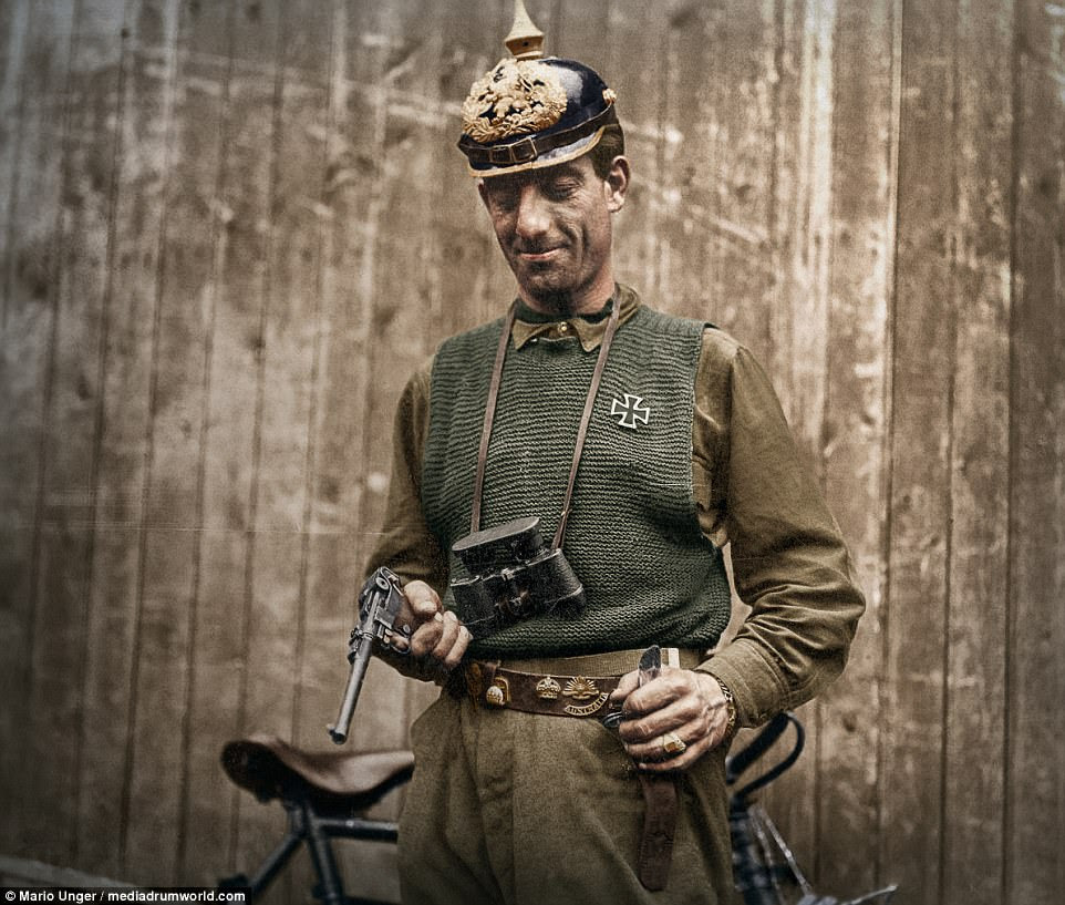 This fascinating picture shows an American soldier displaying his trophies, including a German Iron Cross, pointed helmet and a pistol in 1918. Behind him is a bicycle. Colouriser Mario Unger said he was not hoping to glorify war through his work. He explained: 'I have restored and colourised hundreds of old photographs, war images are just a small part of them. I hate that there is still war on earth, but to restore and colourise this images was still interesting'