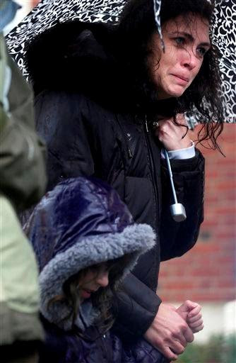 (AP Photo/Seth Wenig). Sarah Baroody holds her daughter Sophia's hand and cries while observing a moment of silence as bells rang 26 times in Newtown, Conn., Friday, Dec. 21, 2012.