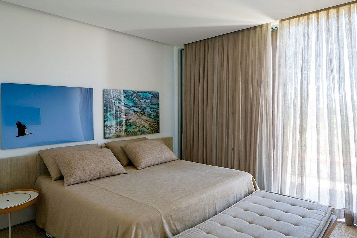 Modern bedroom in white with artwork display above the bed