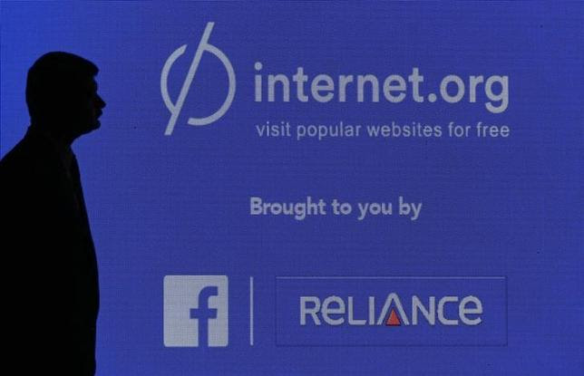 A staff member stands next to a display screen during a joint news conference by Reliance Communications Ltd and Facebook Inc in Mumbai February 10, 2015. REUTERS/Shailesh Andrade