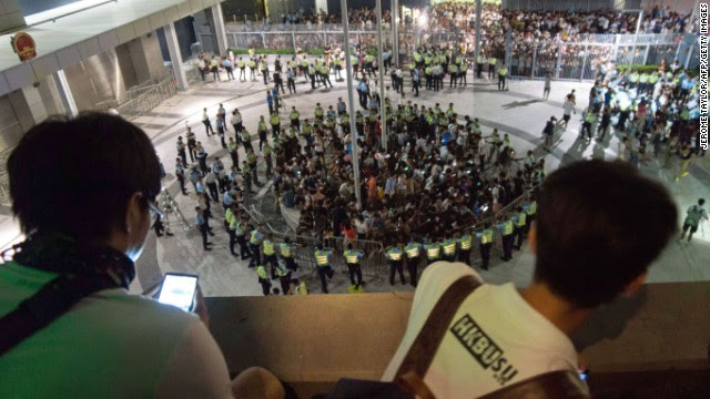 People look from on high as pro-democracy demonstrators are surrounded by police after storming into a courtyard outside Hong Kong's legislative headquarters on Friday, September 26. 