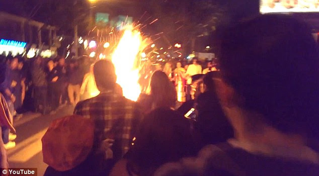 Engulfed in flames: Gilbert Estrada is in the middle of a crowd engulfed in flames