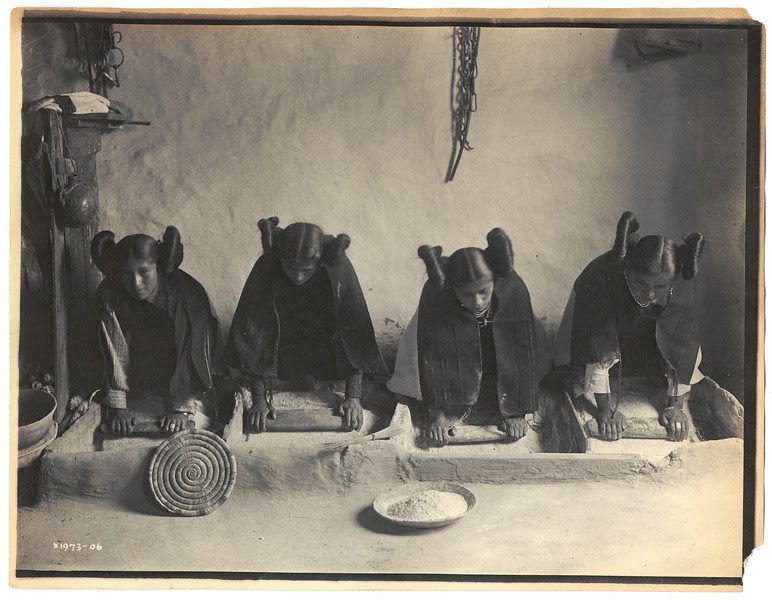 Description of  Title: The mealing trough--Hopi.  <br />Date Created/Published: c1906.  <br />Summary: Four young Hopi Indian women grinding grain.  <br />Photograph by Edward S. Curtis, Curtis (Edward S.) Collection, Library of Congress Prints and Photographs Division Washington, D.C.