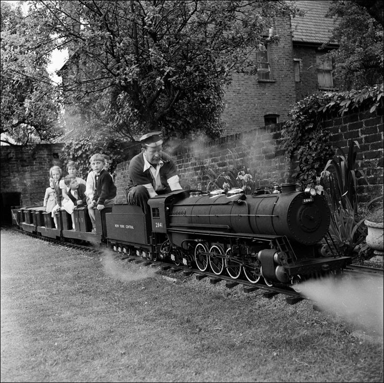 London bank manager George Scanner takes a group of children on a ride around his garden on a miniature steam engine