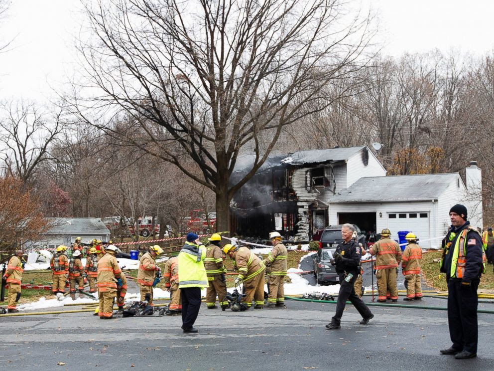 PHOTO: Montgomery County, Md. firefighters stand outside a house where a small plane crashed in Gaithersburg, Md., Dec. 8, 2014.