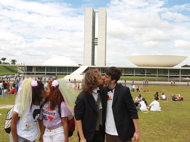 Casais homossexuais se beijam no gramado em frente ao Congresso em protesto contra a presença do deputado Marco Feliciano na presidência da Comissão de Direitos Humanos da Câmara (Foto: Ed Ferreira / Agência Estado)