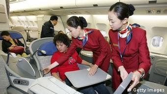 Azafatas chinas con un pasajero de primera clase.  (Foto: China Photos / Getty Images)