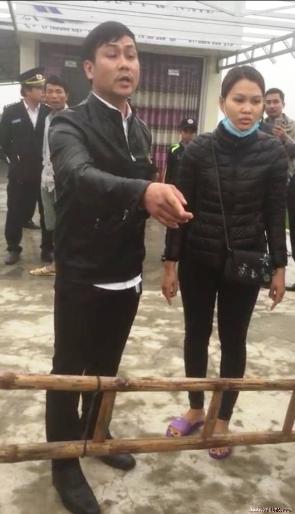  Thượng úy Tuấn (bên trái, hàng đầu) ngăn cản lực lượng chức năng cưỡng chế công trình trái phép