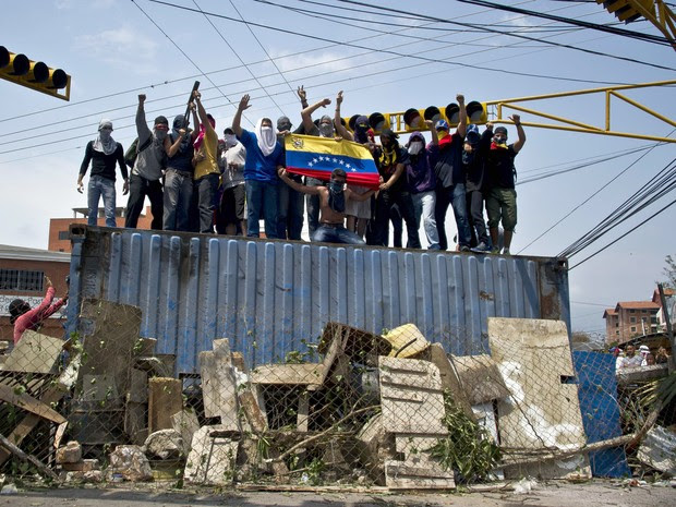 Manifestantes sobem em conteiner para protestar contra Nicolás Maduro na capital de Tachira, na Venezuela. (Foto: Luis Robayo/AFP)