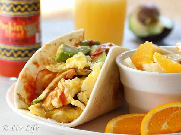 Breakfast Taco with eggs and avocado pictured with fruit