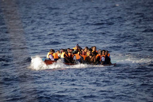 Migrants and refugees fleeing Libya with their dinghy floating low in the water before being helped by members of a Spanish NGO, during a rescue operation at the Mediterranean sea, about 25 miles north of Sabratha, Libya, Thursday, Aug. 18, 2016. At least three people have died on Thursday morning during the sinking of a wooden boat full with migrants as they tried to reach the Italian coasts. (AP Photo/Emilio Morenatti)