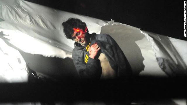 The backlash over Rolling Stone's cover photo of Boston Marathon bombing suspect Dzhokhar Tsarnaev led to the release of new photos on Thursday, July 18, of his capture. The images show Tsarnaev as he emerges from the boat where he hid, his face smeared with blood and multiple snipers' lasers fixed on him. View more photos from the aftermath of the Boston bombing.