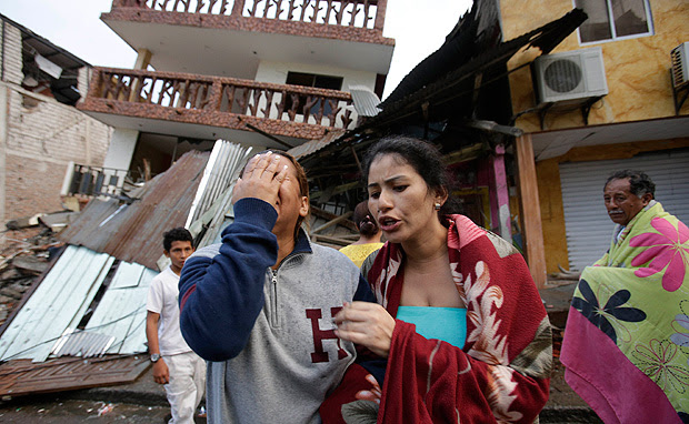 Mulher chora diante de casa destruída pelo terremoto no Equador na cidade de Pedernales