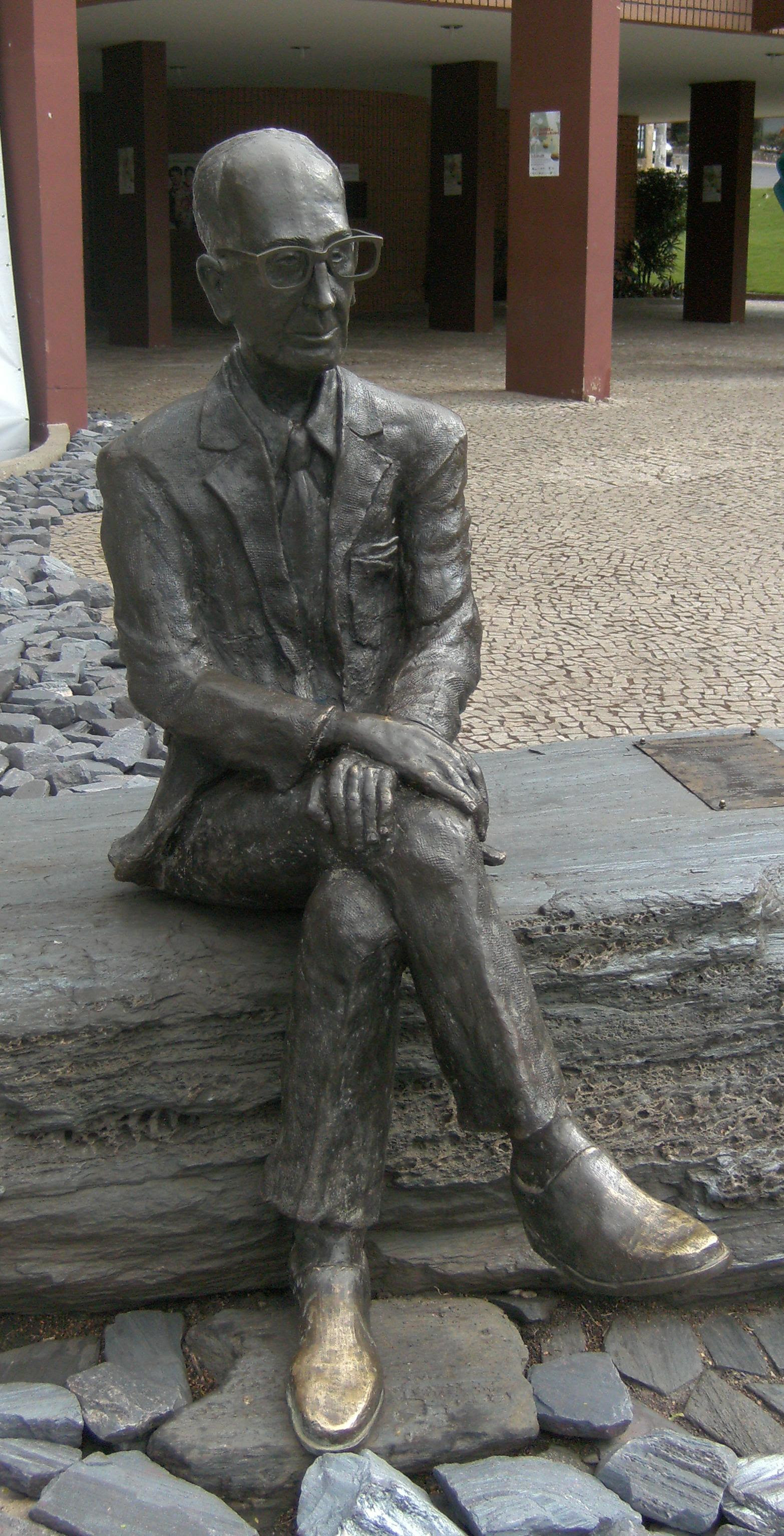 Estátua de Drummond em Itabira. "Outros leram da vida um capítulo, tu leste o livro inteiro"