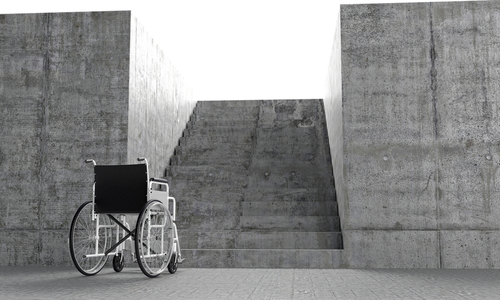 Image of wheelchair in front of barrier via shutterstock.com