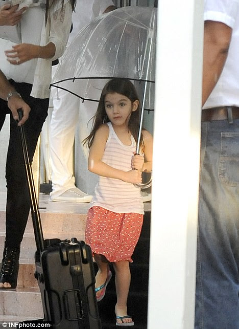 Rain dance! Smiling Suri Cruise larks around in miserable Miami  2