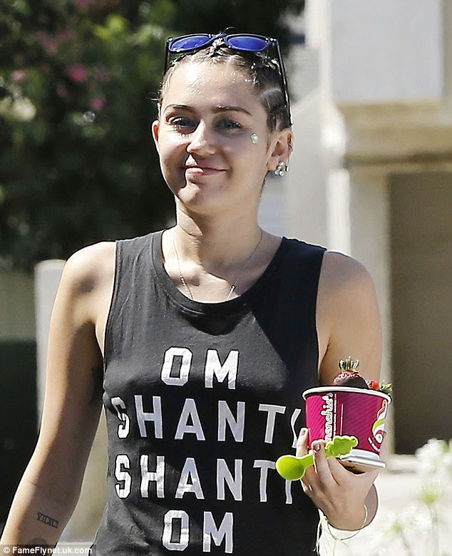 Peace out: The 22-year-old sported a black tank top that bore the Buddhist phrase 'Om Shanti, Shanti Om' - which roughly means 'peace, peace' - highlighting her spiritual beliefs as well as her lack of underwear