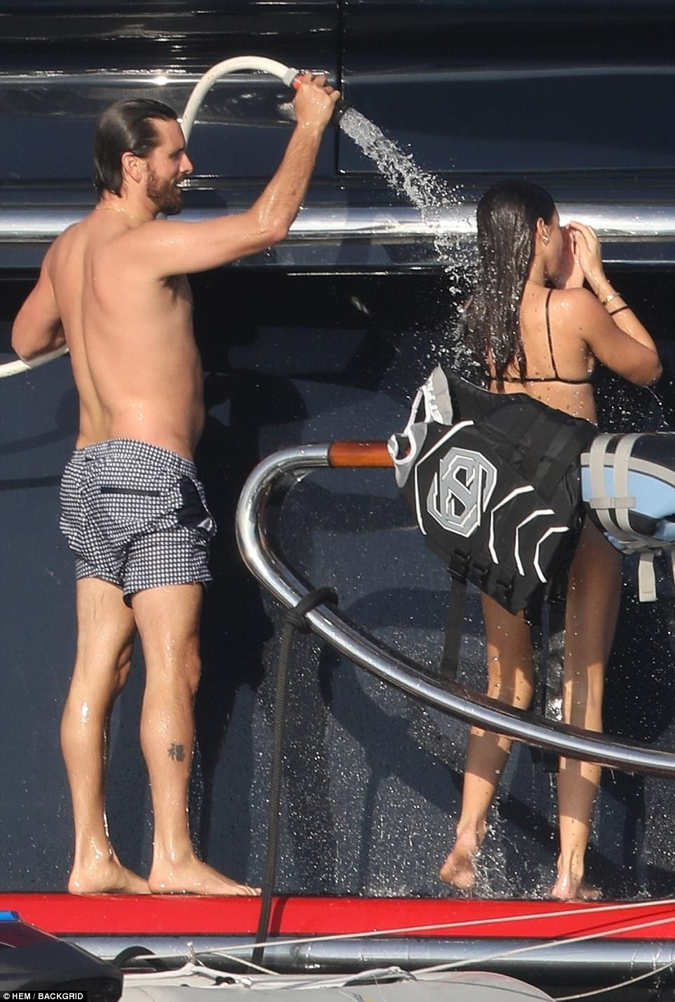 What a gent: Disick helped his younger girlfriend by holding the hose so she could shower