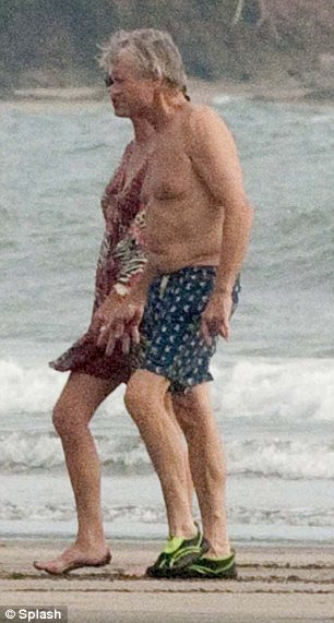 Hand in hand: Michael and his wife Catherine Zeta Jones made the most of a moment alone enjoyed a walk on the beach 