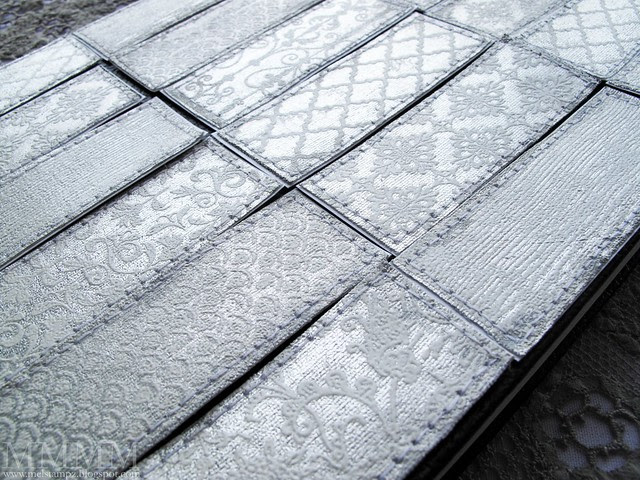 silver leafed sticky back canvas with Skipping Stones Designs embpssed in white