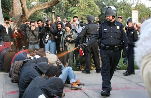 Brutal attack: John Pike can be seen here drenching a line of student protesters in pepper spray