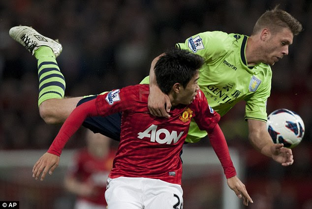 Tussle: Nathan Baker appears to climb on the back of United's Shinji Kagawa when they vie for the ball