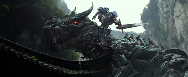 A battle-ready Optimus Prime hitches a ride atop Grimlock in TRANSFORMERS: AGE OF EXTINCTION.