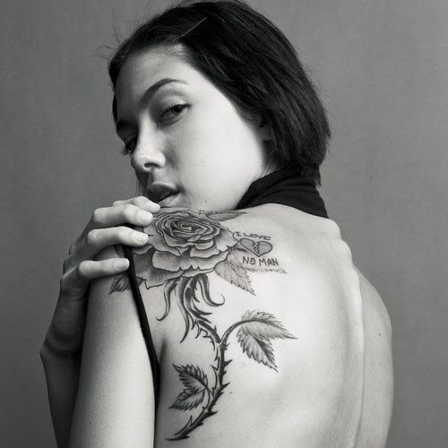 Picture of a girl with a rose tattoo on her upper back