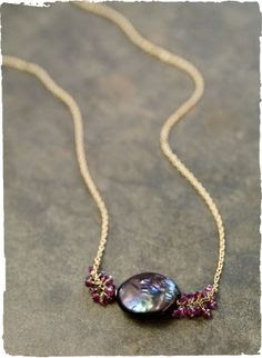 Caspian Pendant Necklace~ Sprinkled with tiny garnet beads, a luminous black pearl floats from a 14kt gold-filled chain.
