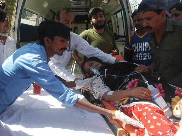 One of the women is helped on to an ambulance after falling unconscious during the exorcism